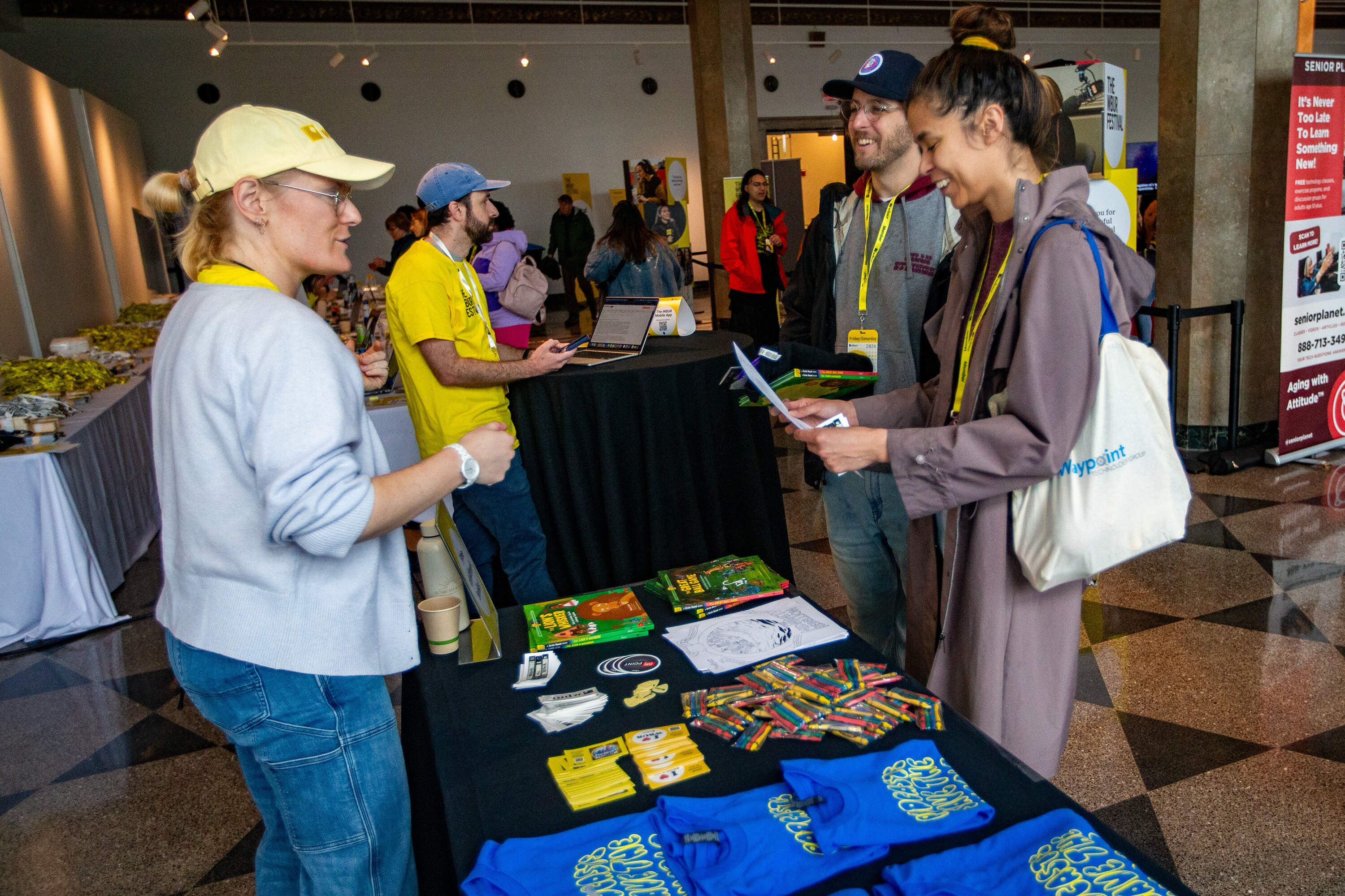 Festival-goers pick up swag from a table at the Hub. (Jesse Costa/WBUR)