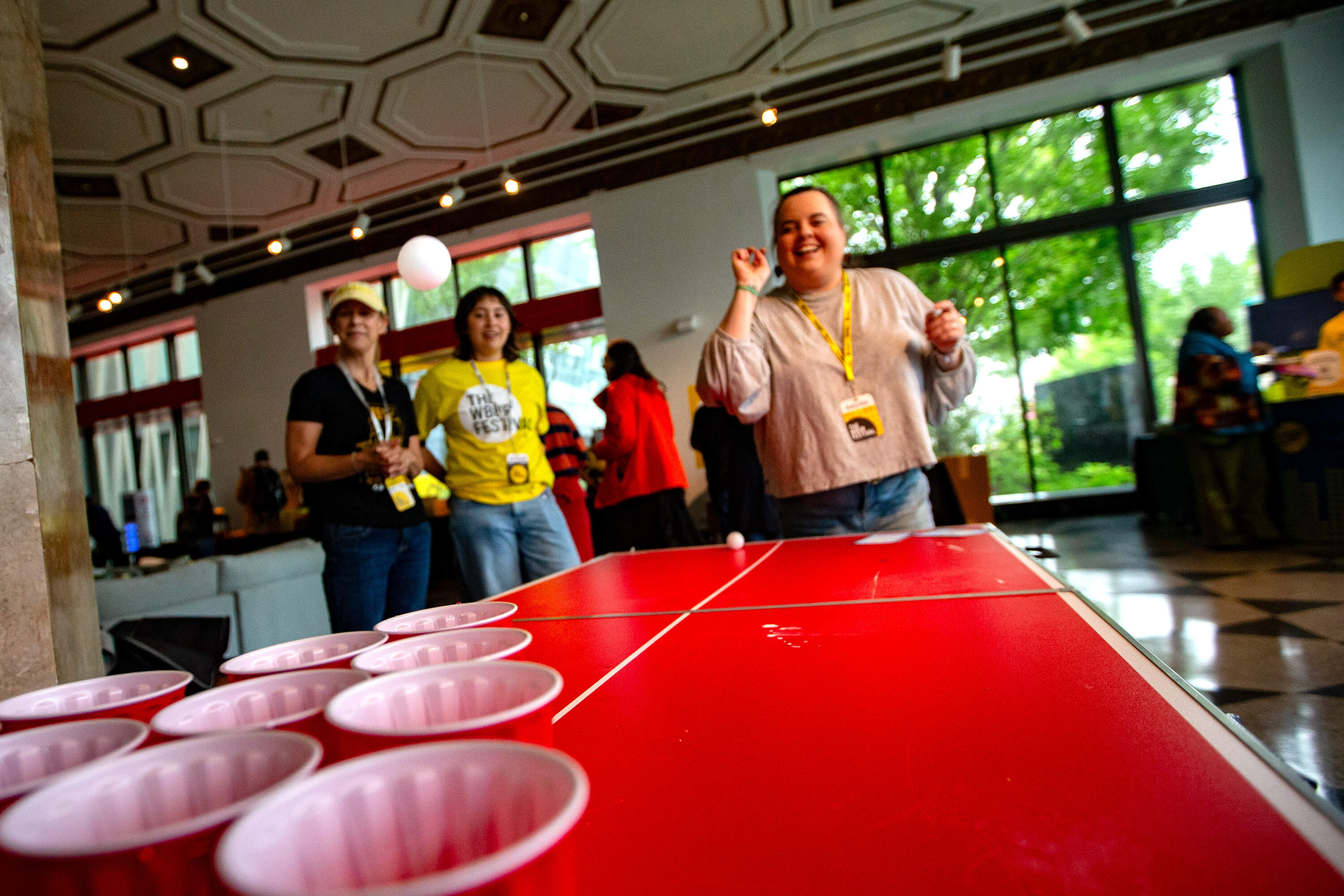 A festival-goer tosses a ping pong ball into a plastic cup at The WBUR Festival street fair. (Jesse Costa/WBUR)