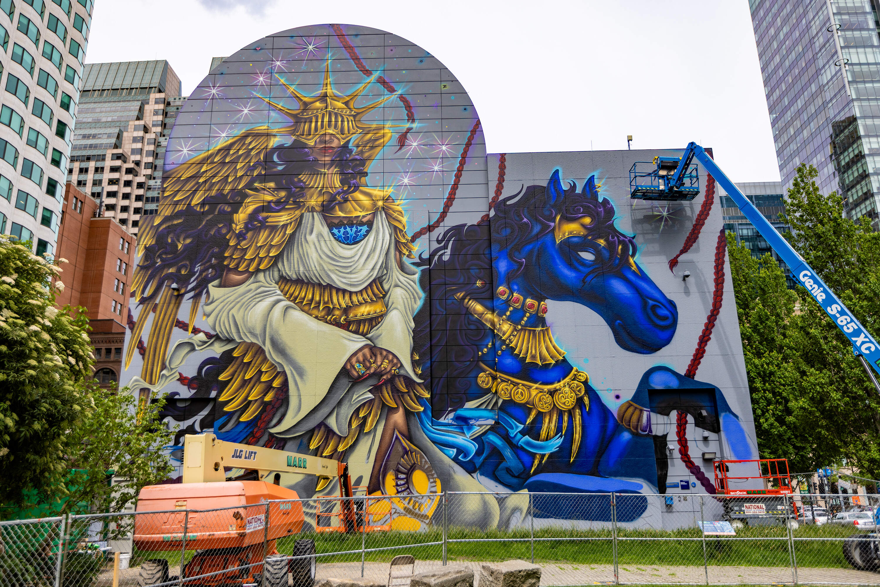 Local artist Rixy puts the finishing touches on her mural “The Midnight Ride” at Dewey Square. (Jesse Costa/WBUR)
