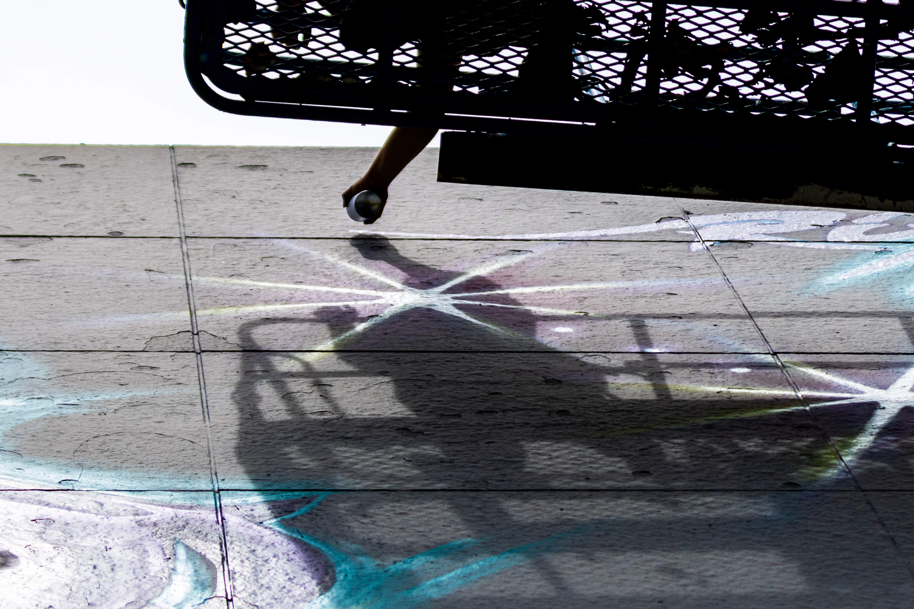 Local artist Rixy signs her name to the nearly completed mural “The Midnight Ride” at Dewey Square. (Jesse Costa/WBUR)