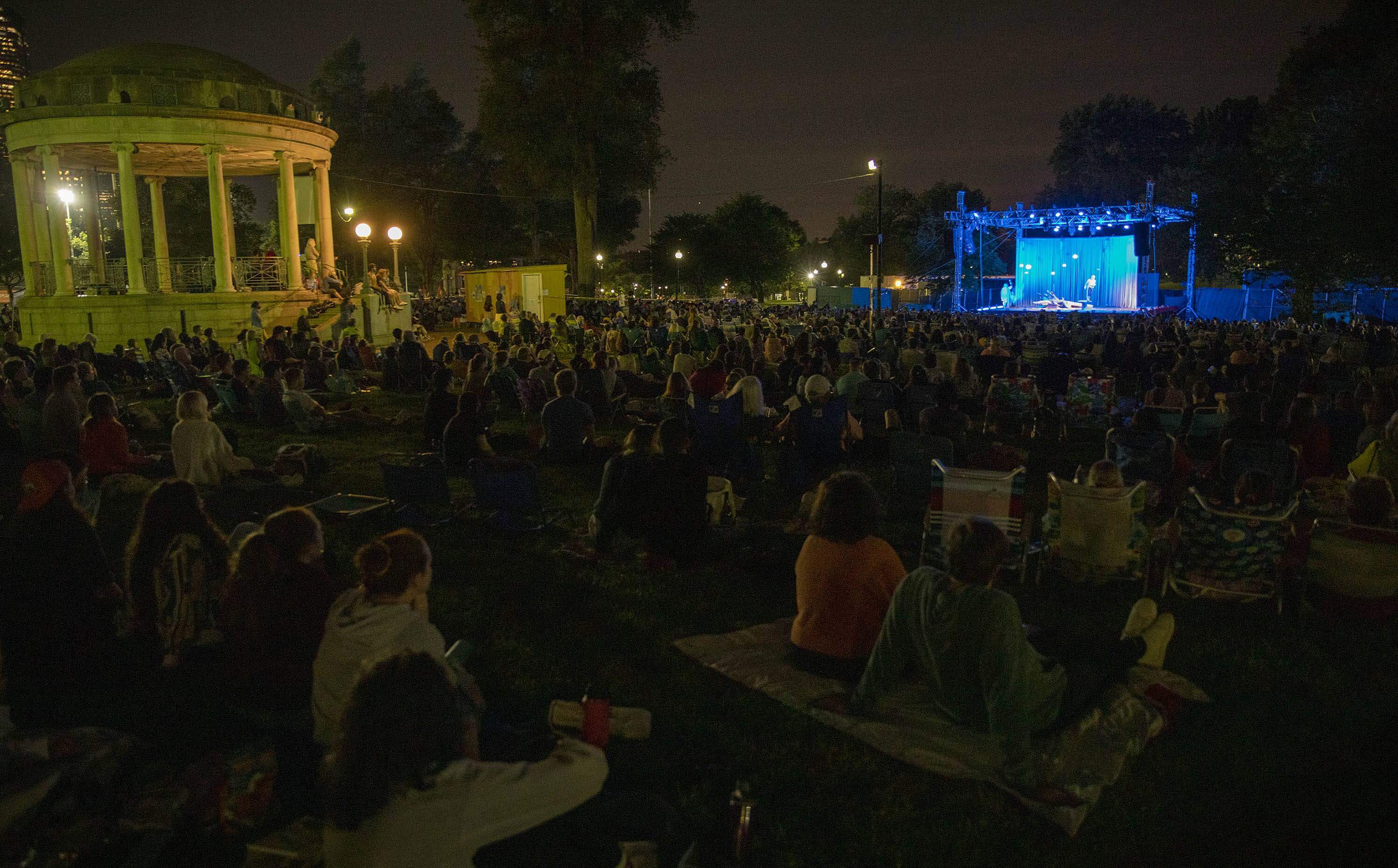 Sitting on blankets and deck chairs, the audience watches the Commonwealth Shakespeare Company's performance of "The Tempest" on Boston Common in 2021. This year, CSC performs "A Midsummer Night's Dream." (Robin Lubbock/WBUR)