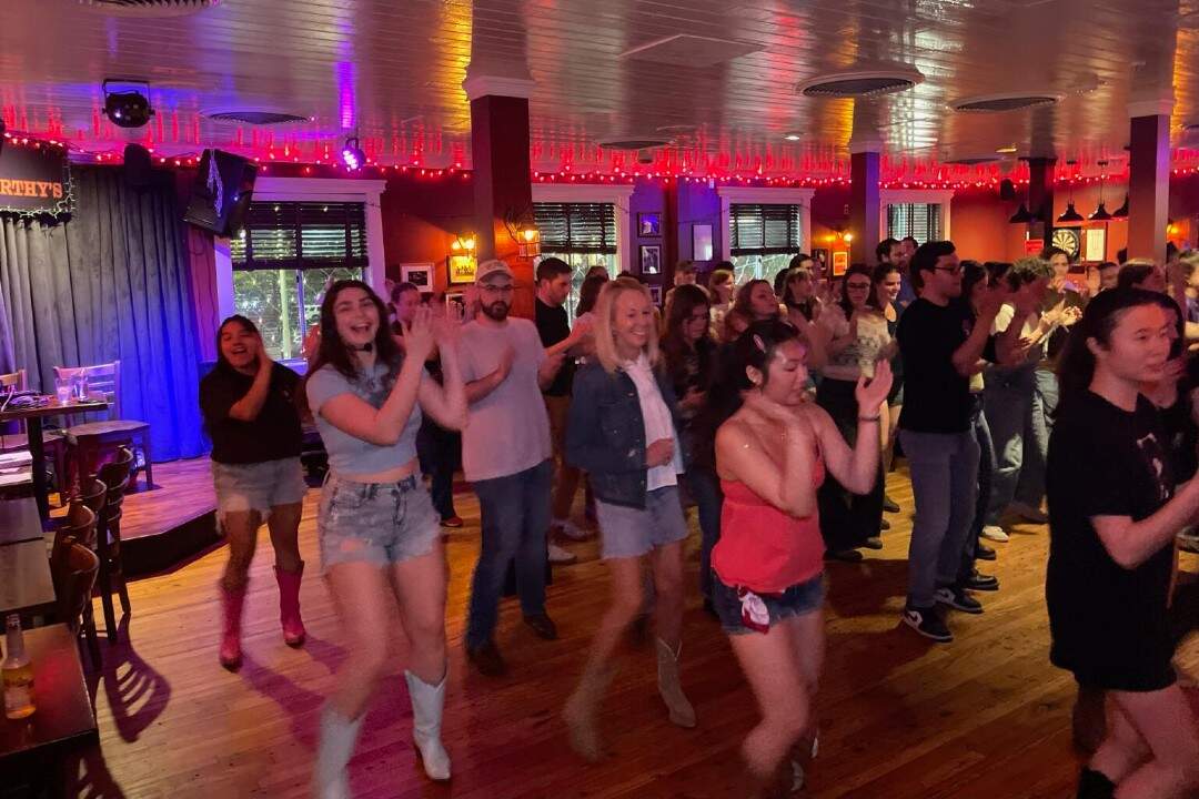 Molly Albert and Vicky Falso (left) dance alongside guests at a line dancing event. (Courtesy Line Dancing Queens)