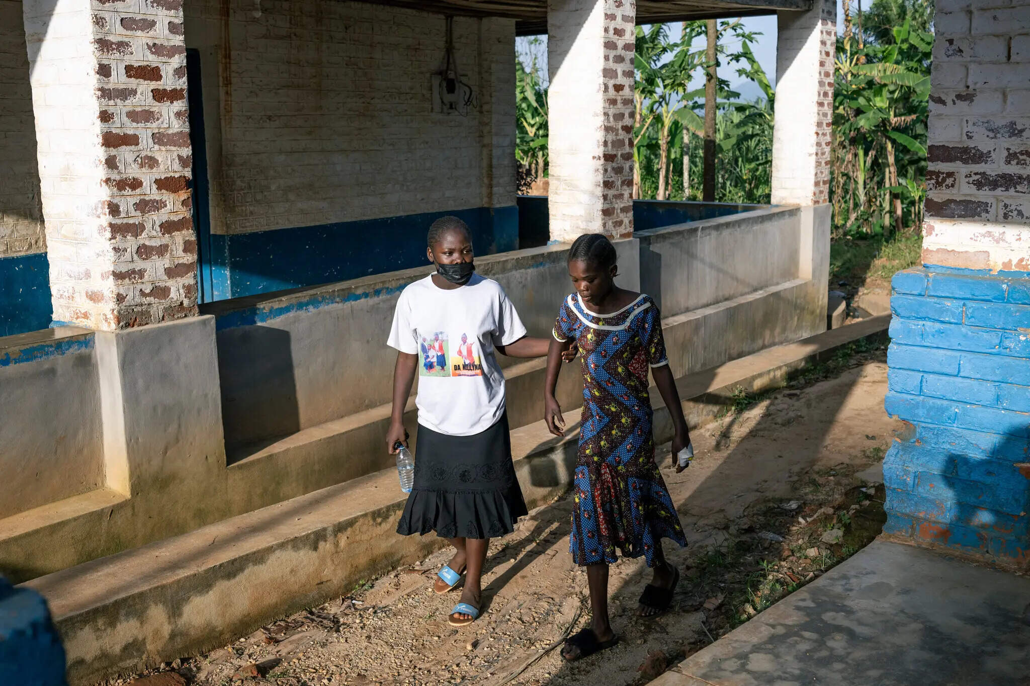 A woman without gloves steadied her sister, who was suspected of having Ebola, at Mongbwalu General Hospital. (Courtesy of Arlette Bashizi for The New York Times)