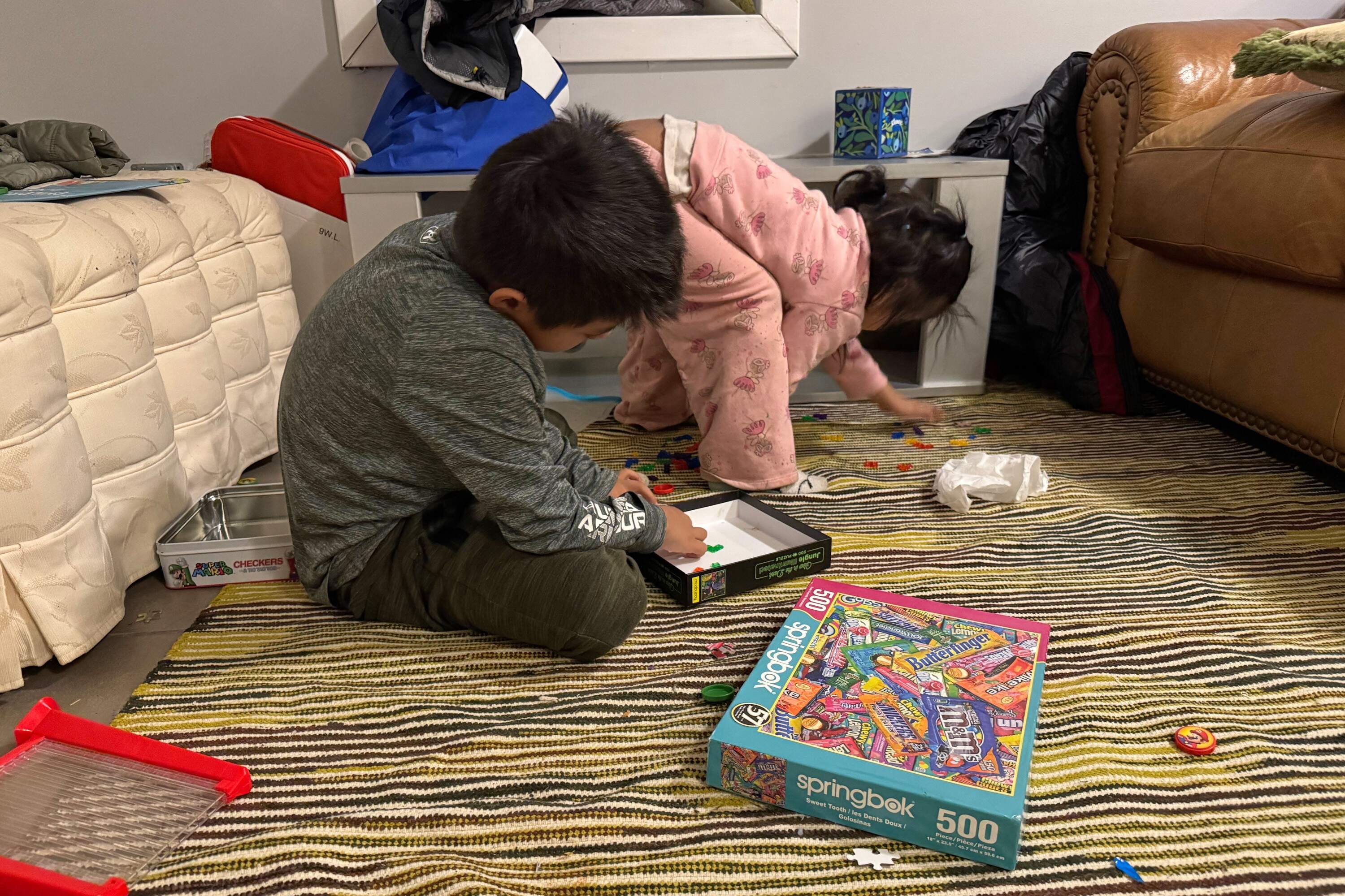 Two immigrant children play in a safe house in Minneapolis, Friday, Jan. 16, after volunteers relocated them from their home to protect them from federal agents. (Jack Brook/AP)