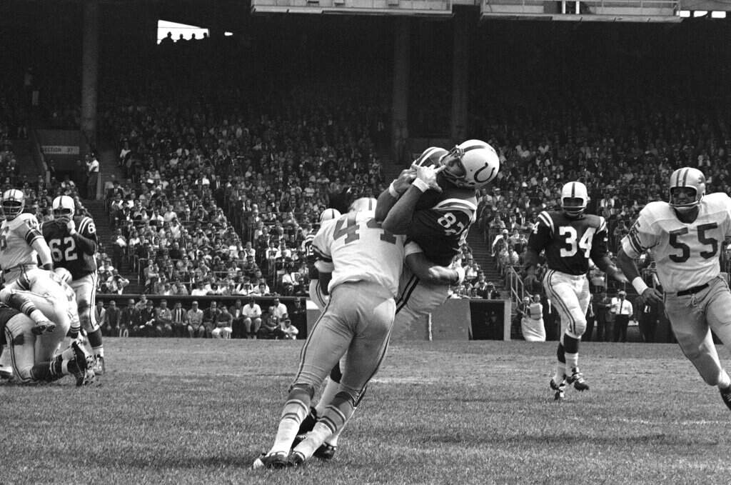 Baltimore Colts end Raymond Berry snags a pass from quarterback John Unitas, Sept. 30, 1962 in Baltimore. (AP Photo, File)