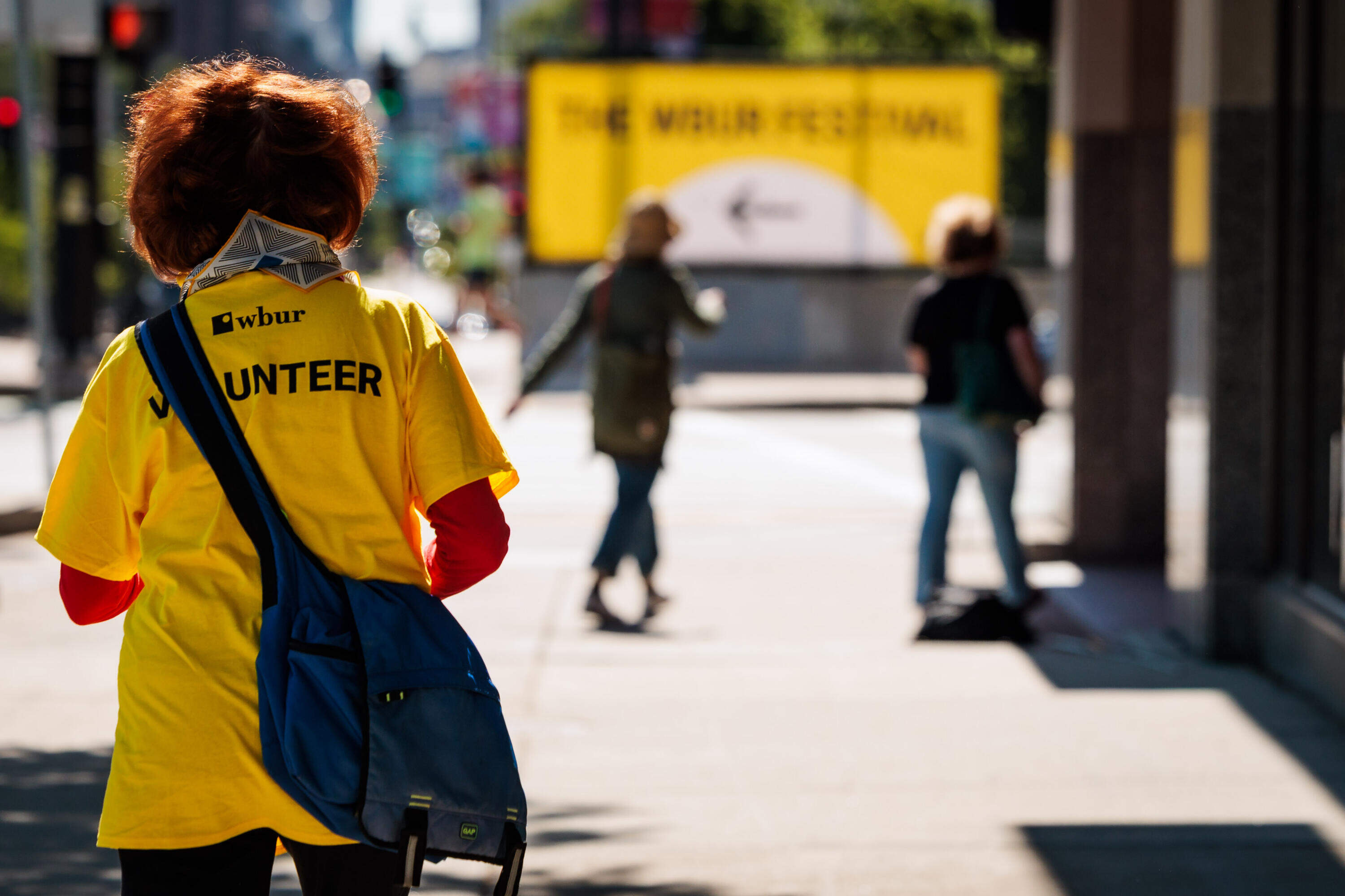 A volunteer walks down Commonwealth Avenue during The WBUR Festival in Boston on May 29. (Nick Grace/Bolt Creative Group for WBUR)