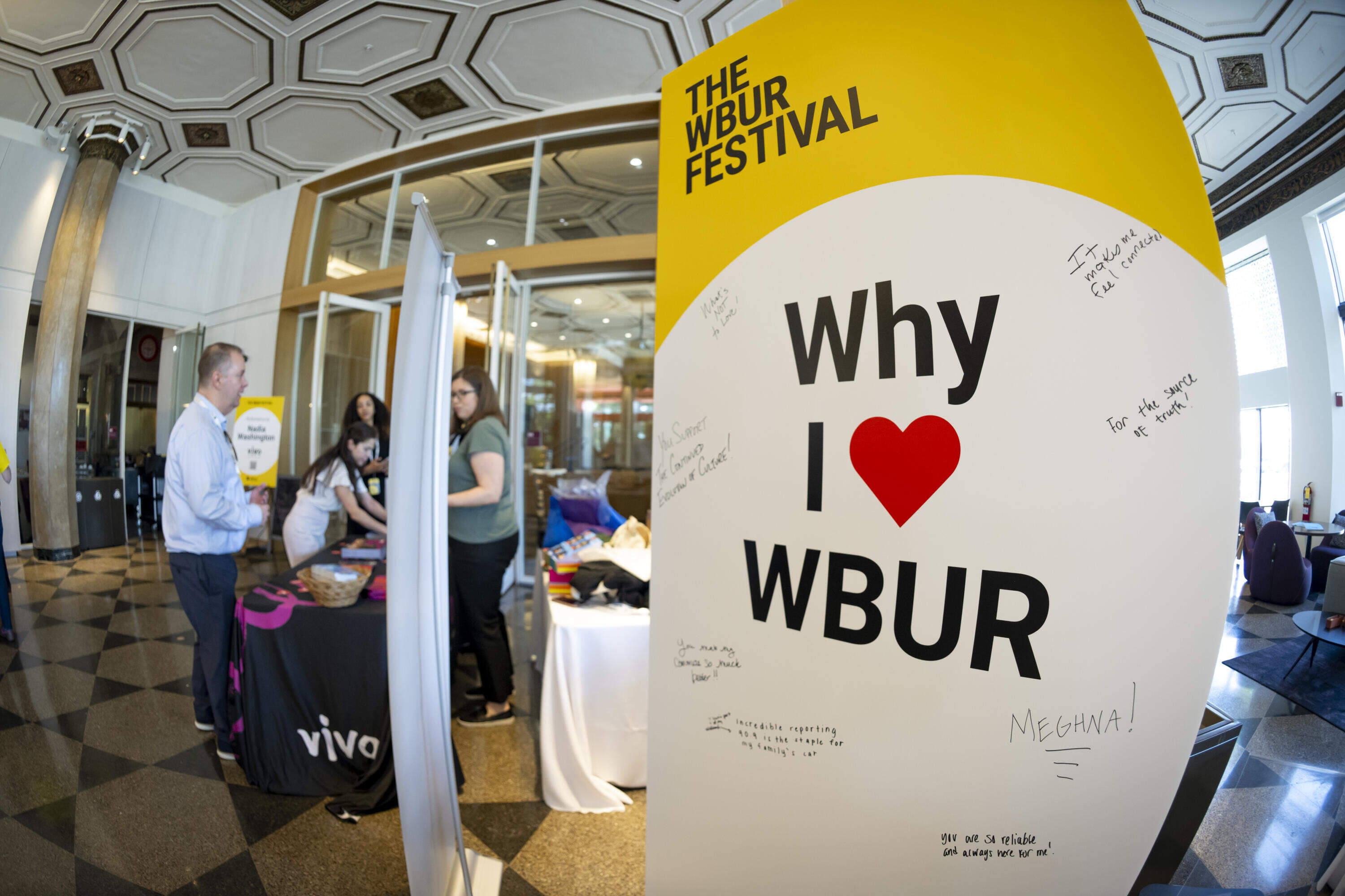 Attendees of The WBUR Festival leave notes of affection for WBUR on a poster board. (Rachel O’Driscoll/Bolt Creative Group for WBUR)