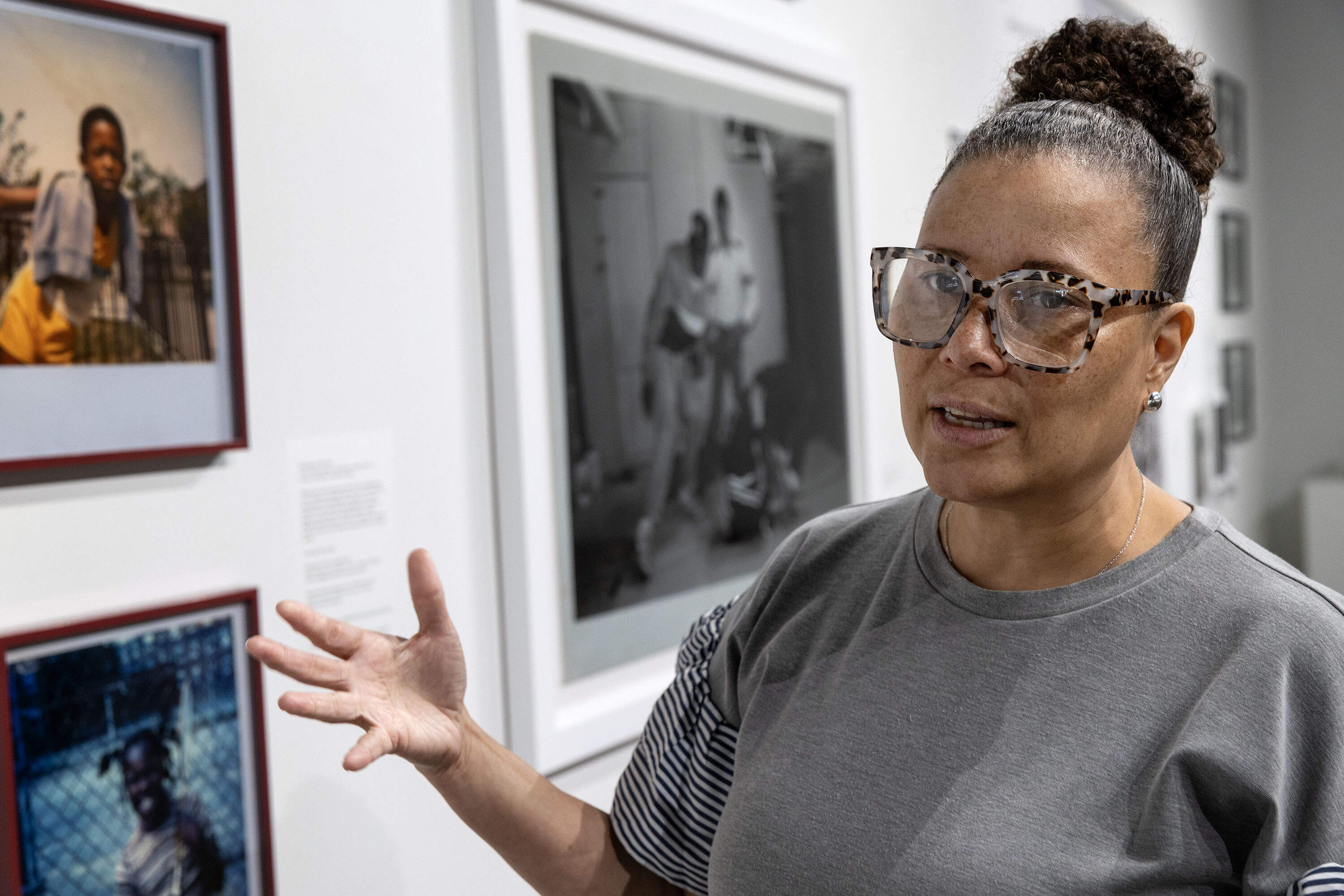 Erin Muirhead McCarty, Director of the Community Art Center in Cambridge, talks with a visitor at the "A Place Called Home" exhibition at the Street Theory Collective Gallery on Massachusetts Ave. (Robin Lubbock/WBUR)