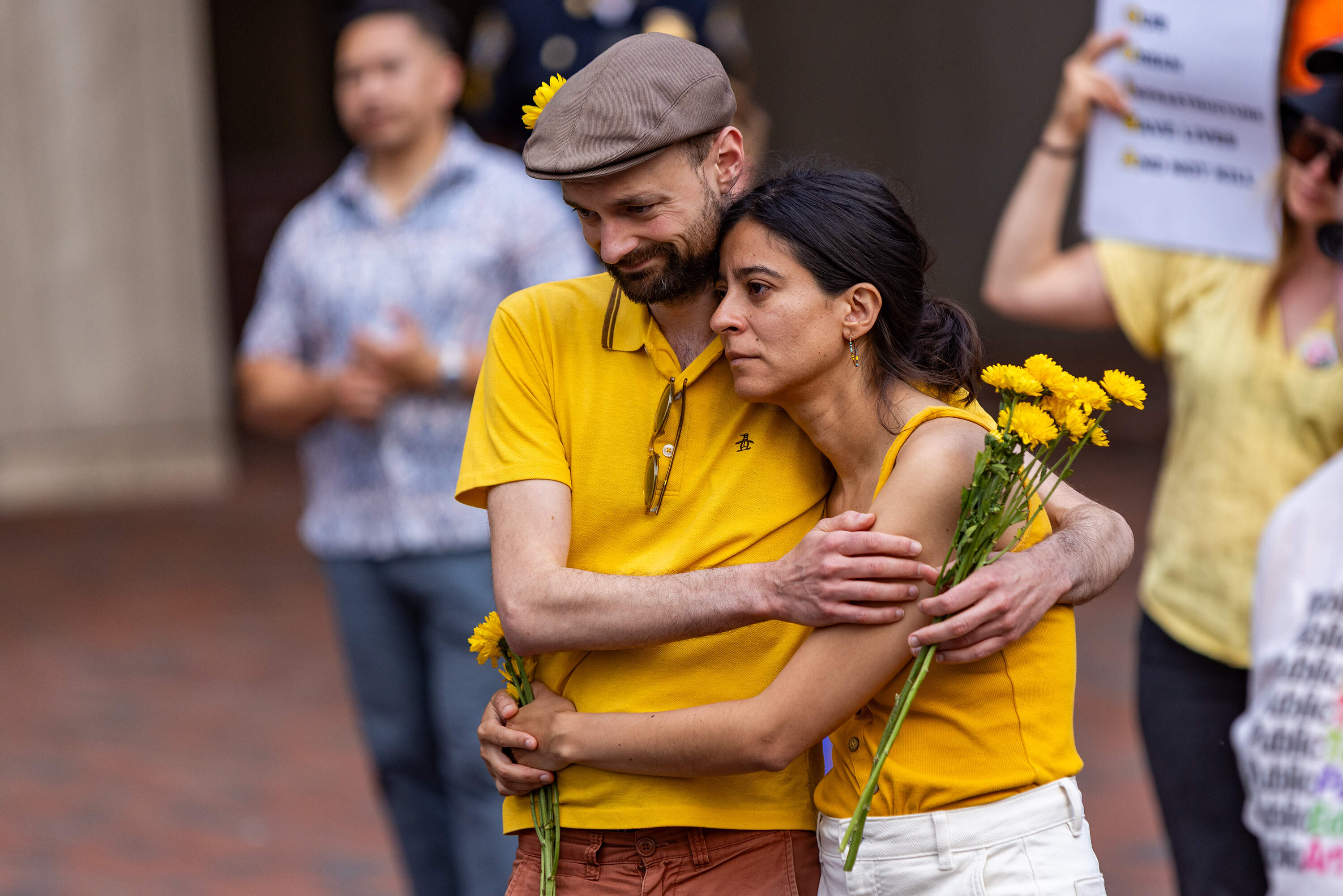 A pair embraces as friends and co-workers remember Louisa Gag. (Jesse Costa/WBUR)