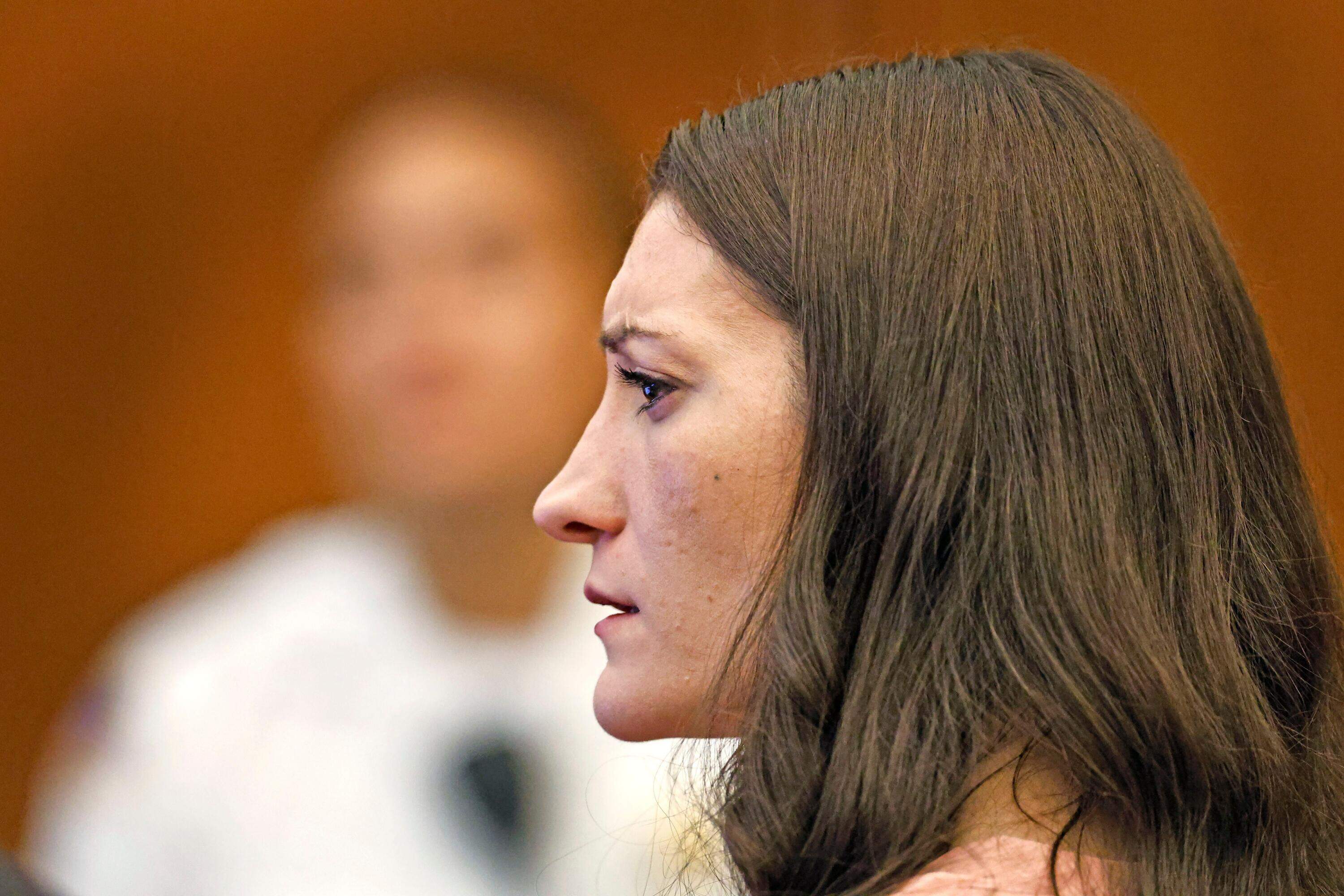Defendant Lindsay Clancy watches as her ex husband Patrick Clancy takes the witness stand. (Greg Derr/The Patriot Ledger via AP, Pool)