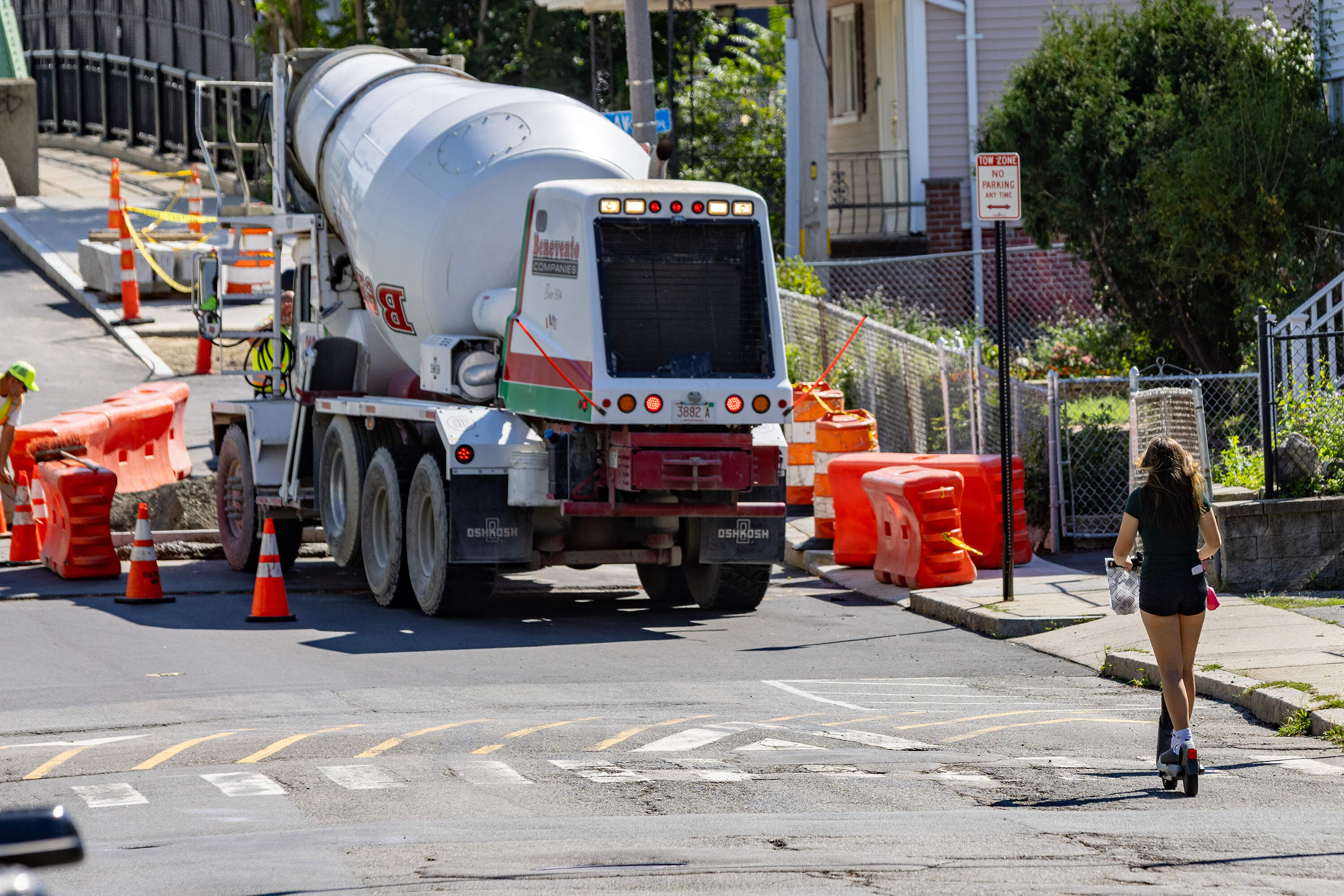 A e-scooter rider approaches a construction site on Cross Street in Somerville. (Jesse Costa/WBUR)